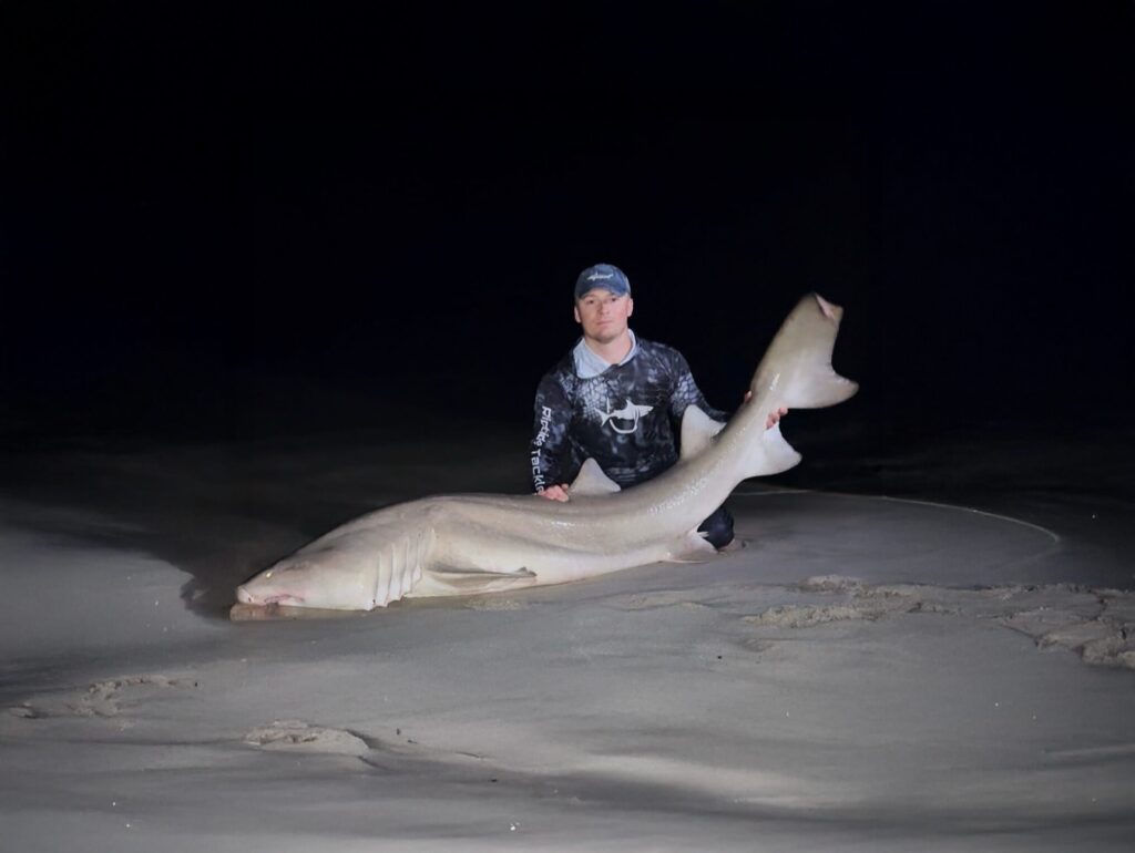 charter captain with big shark